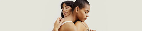 Due donne si abbracciano dolcemente, rappresentando intimità e connessione.